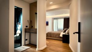 a room with a bed and a bedroom with a mirror at Fivenco Suites - Private Suites w King Bed Modern in Tirana