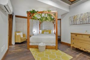 a bedroom with a canopy bed and a yellow chair at auxportesdesMilleIles in Laval