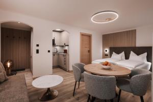 a room with a bed and a table and chairs at Appartement Sport Steger in Saalbach-Hinterglemm