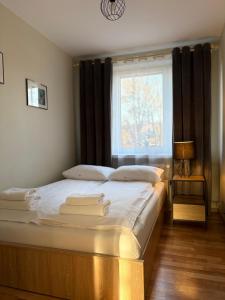 a bedroom with a large bed with a window at Apartament na Błoniach in Sanok