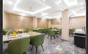 a dining room with tables and green chairs at Hotel Seven Hill Star in Srinagar
