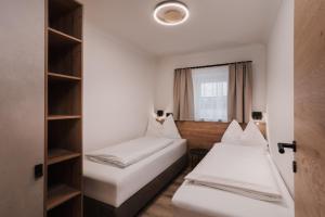 a room with two beds and a window at Appartement Sport Steger in Saalbach-Hinterglemm