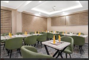 a conference room with tables and green chairs at Hotel Seven Hill Star in Srinagar