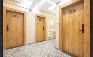 a row of wooden doors in a hallway at Hotel Seven Hill Star in Srinagar