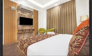 a hotel room with a bed and a flat screen tv at Hotel Seven Hill Star in Srinagar +7 photos
