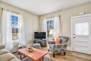 a living room with a couch and chairs and a tv at Brewster's Farm in Florence +40 photos
