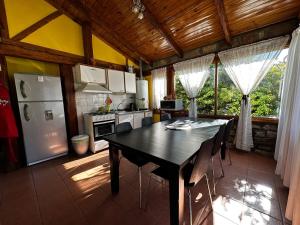 a kitchen with a black table and a refrigerator at Sentidos cardinales casa B Encanto in Perito Moreno
