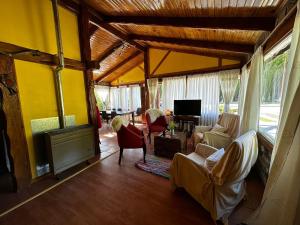 a living room with a couch and chairs and a tv at Sentidos cardinales casa B Encanto in Perito Moreno +3 photos