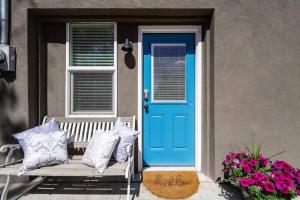 a blue door and a bench on a porch with flowers at Rosemont Cottage in Florence