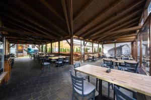an empty restaurant with wooden tables and chairs at Národní dům Podbořany in Podbořany