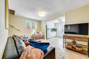 a living room with a couch and a flat screen tv at Rosemont Cottage in Florence +21 photos