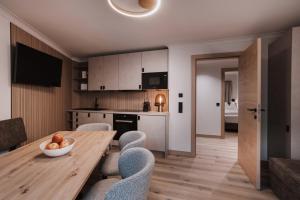a kitchen and dining room with a wooden table and chairs at Appartement Sport Steger in Saalbach-Hinterglemm
