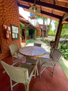 a patio with a table and chairs and an umbrella at Vila Amor - Charmosa e Central in Alto Paraíso de Goiás