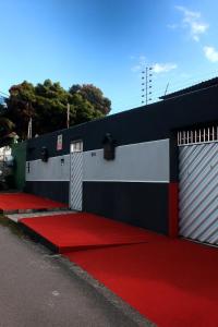 a building with a red carpet and a fence at Quarto - Room Econômico da Maricotinha - No Air Cond in Manaus