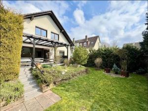 a house with a garden in front of it at YOLKI HAUS moderne Apartments, nahe Wölfersheimer See in Wölfersheim
