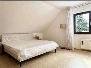 a white bedroom with a bed and a window at YOLKI HAUS moderne Apartments, nahe Wölfersheimer See in Wölfersheim