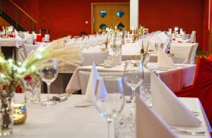 a long table with white table cloths and wine glasses at Národní dům Podbořany in Podbořany +99 photos