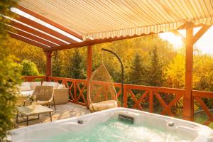 a jacuzzi tub on a deck with at Villa Emausy in Luhačovice