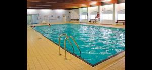 a large swimming pool with blue water in a building at Graham's Dream in Heysham