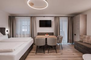 a hotel room with a bed and a table and a couch at Appartement Sport Steger in Saalbach-Hinterglemm