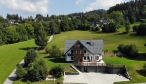 an aerial view of a house on a green field at Psí bouda Benecko in Benecko