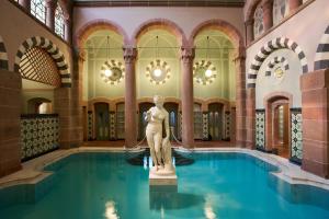 a statue of a woman in a pool in a building at Mokni's Palais Hotel & SPA in Bad Wildbad