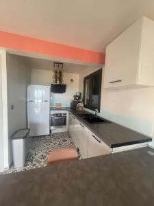 a kitchen with a refrigerator and a counter top at Estrella, véritable havre de paix climatisé avec spa in Sainte-Marie +5 photos