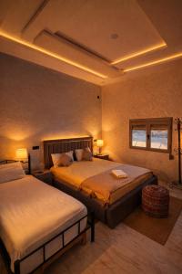 a hotel room with two beds and two windows at Riad Mifis in Rissani