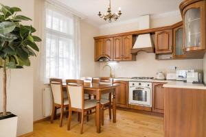 a kitchen with wooden cabinets and a table and chairs at Villa Emausy in Luhačovice