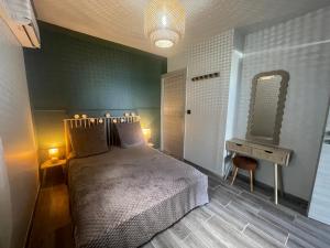 a bedroom with a bed and a mirror and a table at Estrella, véritable havre de paix climatisé avec spa in Sainte-Marie
