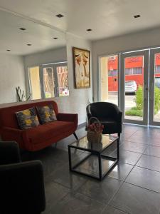 a living room with a red couch and a table at Hotel Capri in Iquique