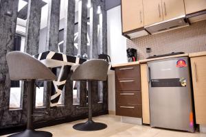 a kitchen with two chairs and a refrigerator at LuxRoom in Patra