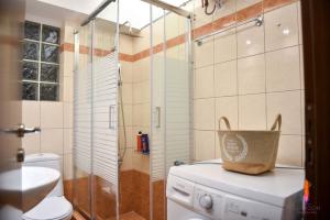 a bathroom with a washing machine and a glass shower at LuxRoom in Patra +46 photos