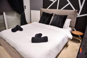 a large white bed with two hats on it at LuxRoom in Patra