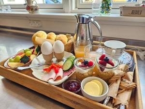 a tray of food with eggs and fruit on a table at Villa Vendel B&B in Løkken