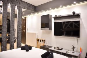 a room with a bed and a tv on the wall at LuxRoom in Patra