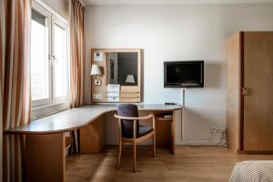a hotel room with a desk and a tv at Hotell Falköping, Sure Hotel Collection by Best Western in Falköping