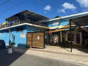 a blue building with a balcony on a street at Rincon Dorms in Rincon