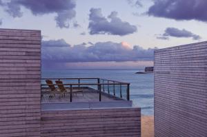 a group of chairs sitting on a balcony overlooking the ocean at Martinhal Sagres Beach Family Resort Hotel in Sagres