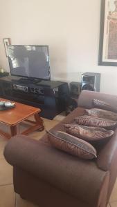 a living room with a couch and a television at Feel Good in Gqeberha