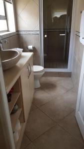 a bathroom with a toilet and a sink and a shower at Feel Good in Gqeberha