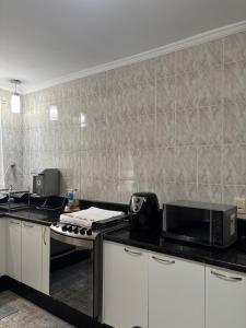 a kitchen with a counter top with a microwave at Casa no Roteiro do Vinho in São Roque +8 photos