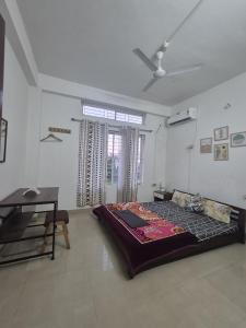 a bedroom with a bed in the middle of a room at Boho Rooms in Jorhat
