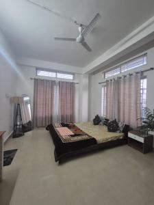 a bedroom with a bed and a ceiling fan at Boho Rooms in Jorhat
