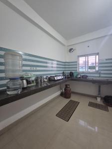 a kitchen with a long counter in a room at Boho Rooms in Jorhat