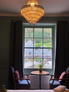 a window with a table and chairs and a chandelier at Rock House Hotel in Lynmouth