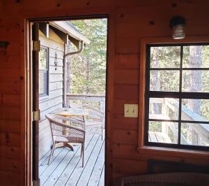 a porch of a cabin with a chair and a window at Coastal Cabin above the Clouds in Brookings