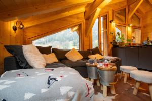 a living room with a bed and a couch at La Rose des neiges à Châtel in Châtel +166 photos