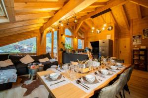 a dining room and living room with a large wooden table at La Rose des neiges à Châtel in Châtel