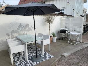 a table and chairs with an umbrella on a patio at Central guesthouse in Halmstad